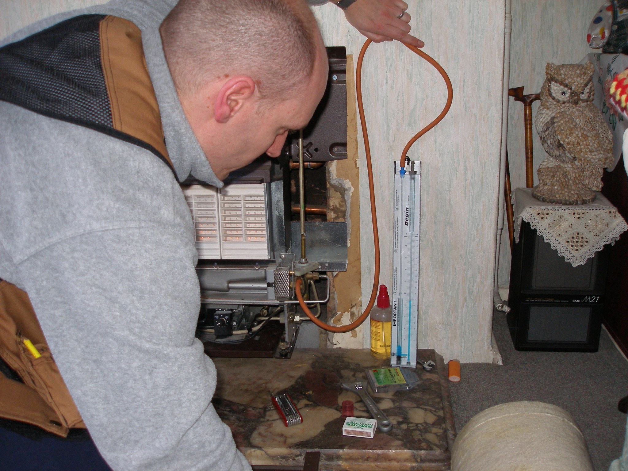 Thomas setting up a manometer at an old back boiler