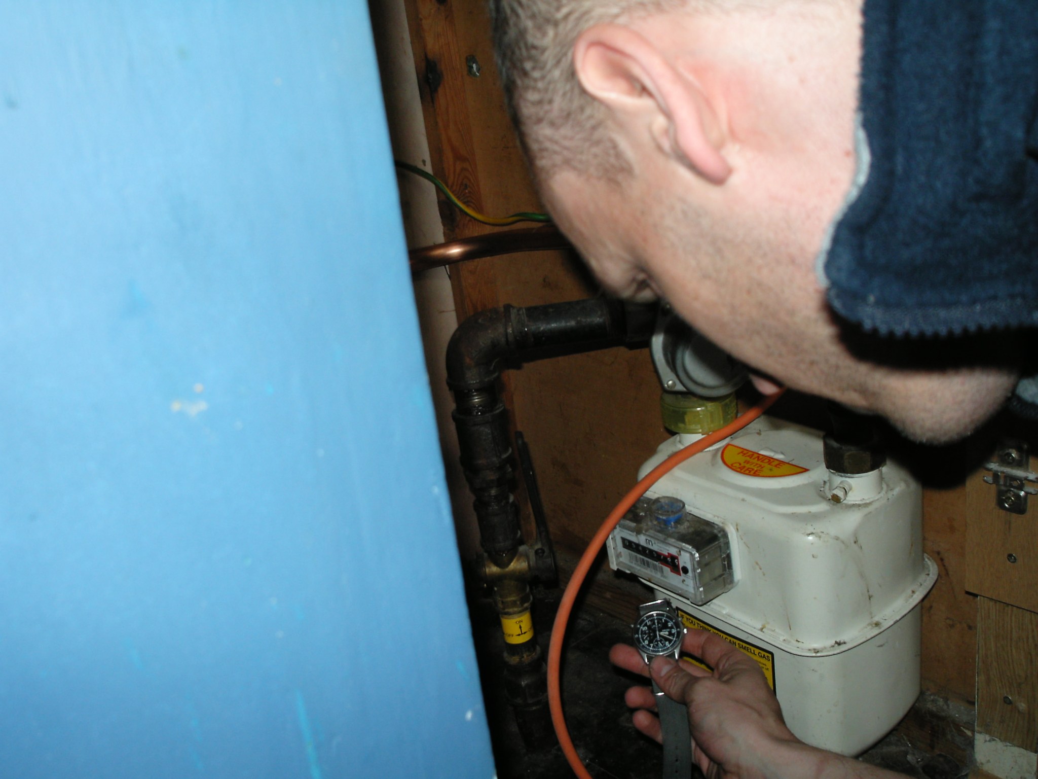 Thomas at a gas meter in a cupboard