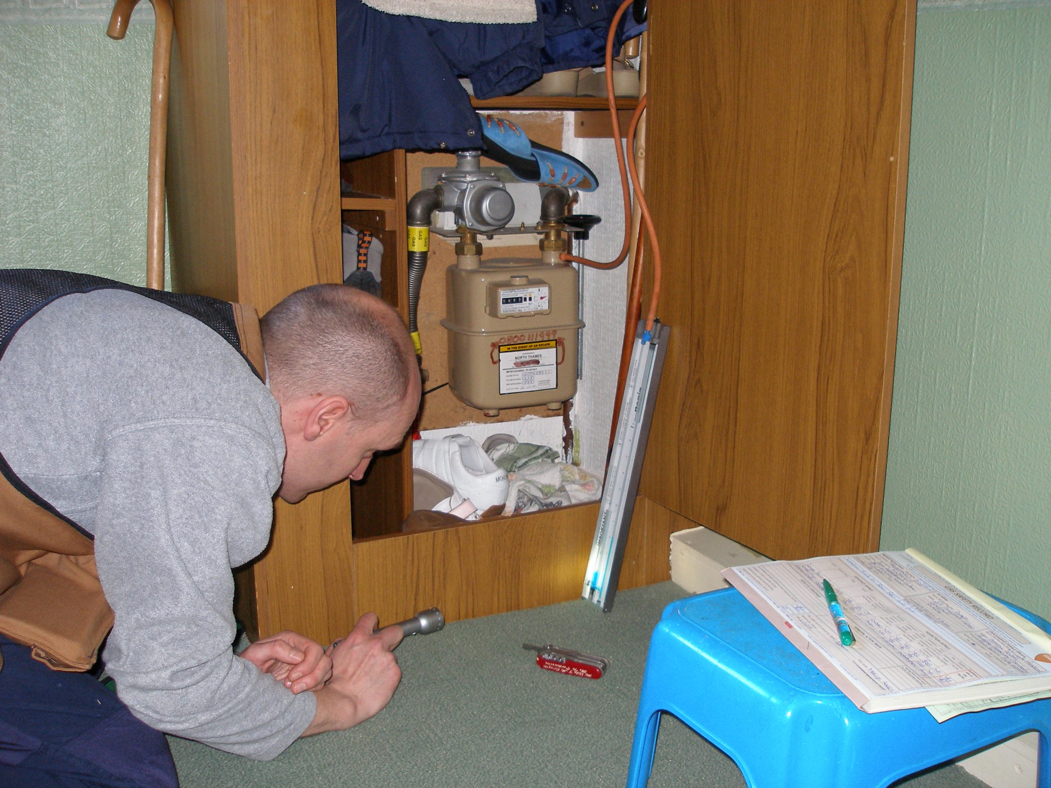 Working at a meter cupboard with the paperwork to hand