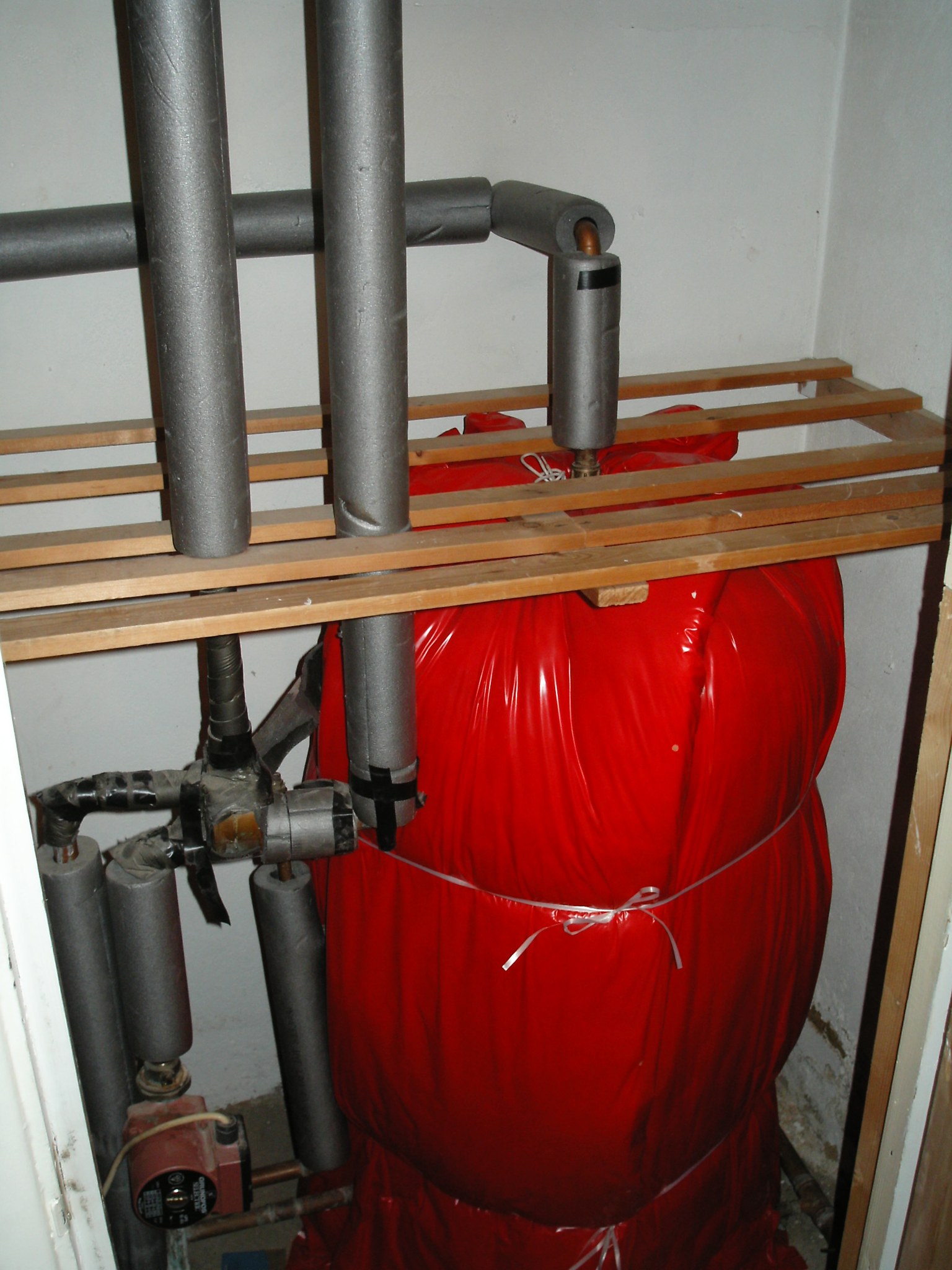 Insulated pipework over a lagged hot water cylinder